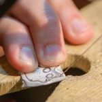 Teilnehmerin sägt eine Schmuckform aus Silberblech bei einem Goldschmiede-Workshop in Liestal.